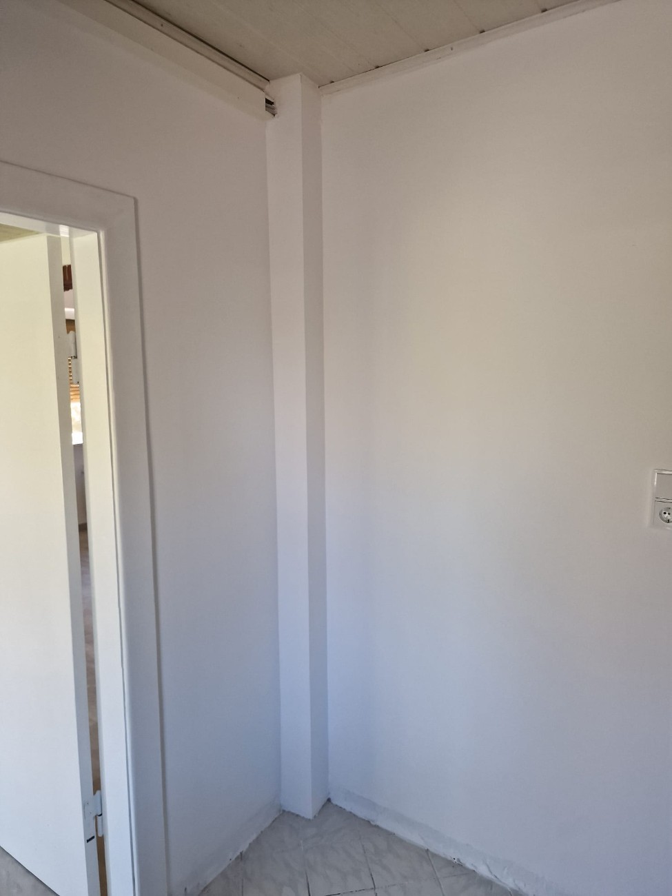 Wand mit frischem Innenanstrich und Malerwerkzeug
